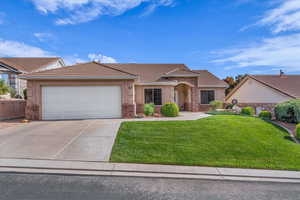 Single story home featuring a tile roof, a front lawn, concrete driveway, an attached garage, and stucco siding