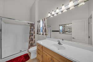 Full bathroom with a stall shower, vanity, and light tile patterned flooring