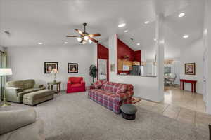 Living area with light carpet, high vaulted ceiling, light tile patterned floors, recessed lighting, and ceiling fan