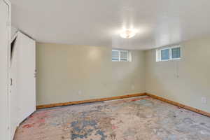 Basement with baseboards and a textured ceiling