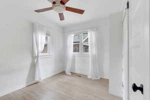 Empty room with light wood finished floors and a ceiling fan