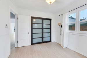 Entryway featuring wood finished floors and crown molding