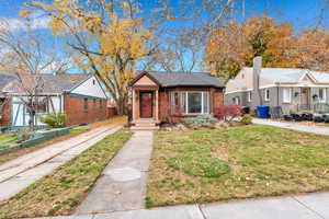 Bungalow-style house with a front lawn and brick siding