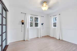 Empty room featuring light wood-style flooring, ceiling fan, and crown molding