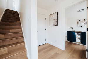 Stairs featuring wood finished floors and baseboards