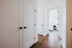 Hallway with dark wood-style flooring and baseboards