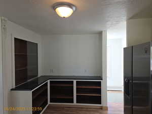 Spare room with a textured ceiling and dark wood-style flooring
