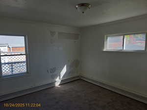 Spare room with carpet floors, ornamental molding, and a baseboard radiator