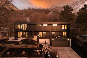 View of front of house with a mountain view, driveway, and a garage