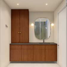 Bathroom with vanity, light tile patterned flooring, tiled shower, and recessed lighting