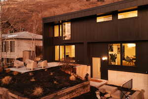 Back of house with board and batten siding and a patio area