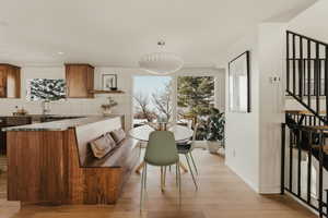 Dining space with light wood finished floors and stairway