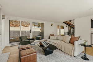 Living area with light wood finished floors and stairway