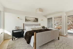 Bedroom featuring multiple windows and light wood-style flooring