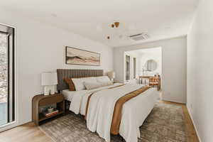 Bedroom featuring cooling unit and light wood finished floors