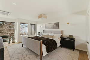 Bedroom with cooling unit and light wood finished floors