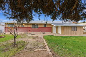 View of front facade with brick siding, a front yard, and board and batten siding