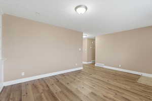 Spare room with light wood-style flooring and a textured ceiling