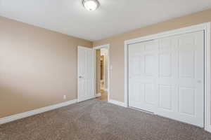 Unfurnished bedroom featuring carpet and a closet