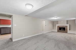 Unfurnished living room with light carpet and a fireplace