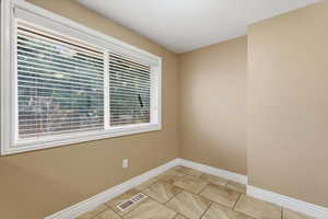 Unfurnished room with baseboards and light tile patterned floors