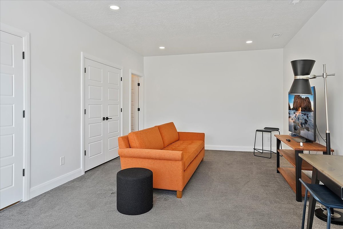 Sitting room featuring carpet floors, a textured ceiling, and recessed lighting