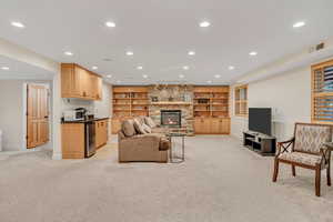 Basement family room with light carpet, a fireplace, recessed lighting, and built in shelves