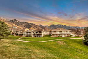 Common Space - View of front facade featuring a front lawn, a mountain view, stairs, a balcony, and a residential view