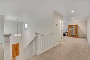 Corridor with carpet, an upstairs landing, and recessed lighting
