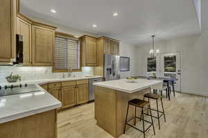 Kitchen featuring a center island, light wood-style flooring, appliances with stainless steel finishes, recessed lighting, and decorative backsplash