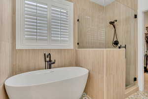 Main Level Primary Bathroom featuring a shower stall and a freestanding bath