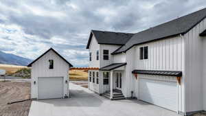 Back of property featuring board and batten siding, a standing seam roof, a shingled roof, and a metal roof