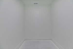 Laundry area featuring concrete floors and baseboards