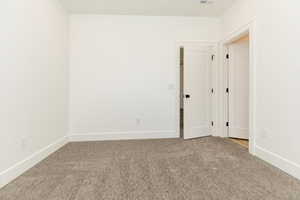 Carpeted empty room with baseboards