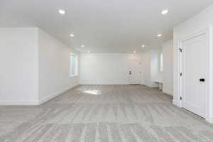 Empty room featuring light carpet and recessed lighting