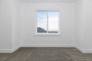 Carpeted empty room featuring baseboards