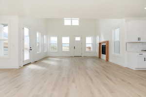 Unfurnished living room featuring light wood-style flooring and baseboards
