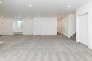 Below grade area with recessed lighting, stairs, and light colored carpet