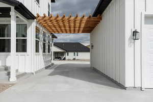 View of home's exterior with board and batten siding and a pergola