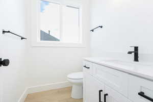 Half bath featuring vanity and light wood-type flooring