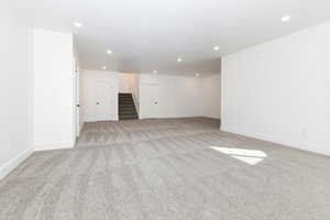 Spare room with light colored carpet, recessed lighting, and stairs