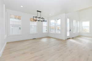 Unfurnished dining area with light wood-style flooring and recessed lighting