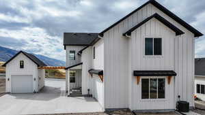 Back of house with board and batten siding, a mountain view, a garage, a metal roof, and a standing seam roof