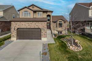 View of front of home featuring concrete driveway, roof with shingles, an attached garage, stucco siding, and a front yard