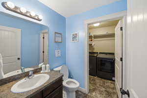 Bathroom with washer and clothes dryer, vanity, and a spacious closet