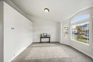 Spare room with carpet floors and vaulted ceiling