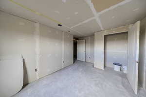 Unfurnished bedroom with unfinished concrete floors