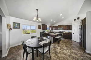 Dining room with a chandelier, vaulted ceiling, and recessed lighting