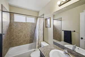 Full bathroom featuring shower / tub combo with curtain and vanity