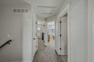 Hall with light colored carpet and attic access